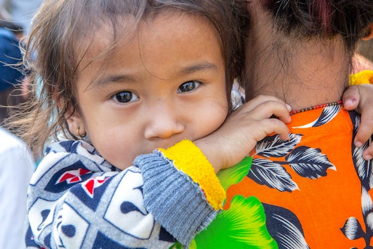Child being held by mother.
