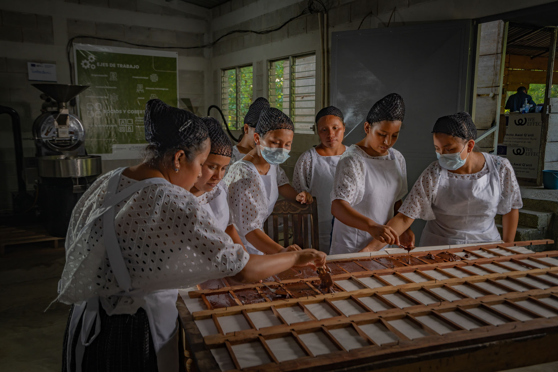 Women make chocolate in a workshop.