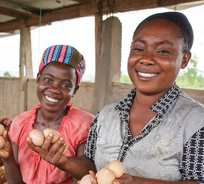 Two women holding eggs and smiling.
