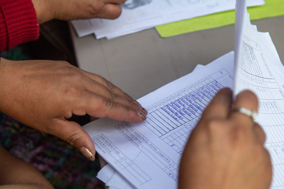 Close up of a person's hands flipping through papers.