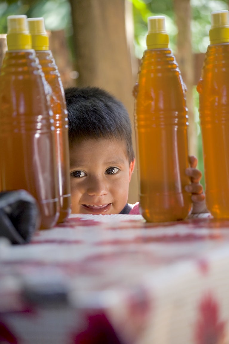 A kid is shown next to honey.