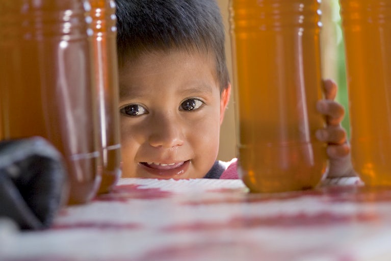 A kid is shown next to honey.
