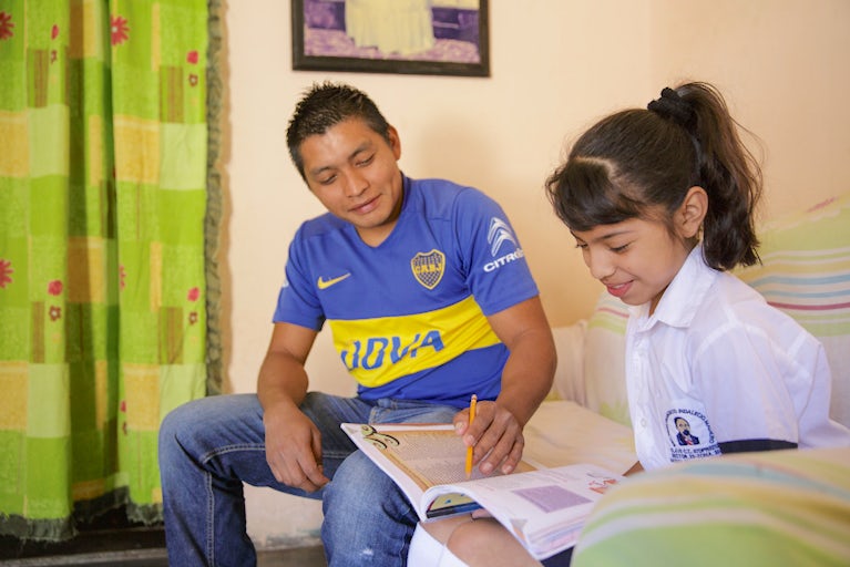 father helps daughter with school work
