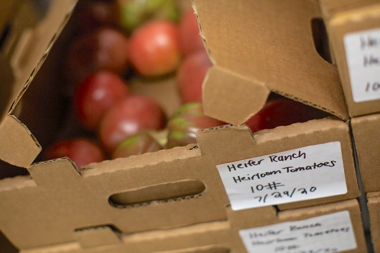 Close up photo of a box of tomatoes with a label that reads Heifer Ranch Heirloom Tomatoes.
