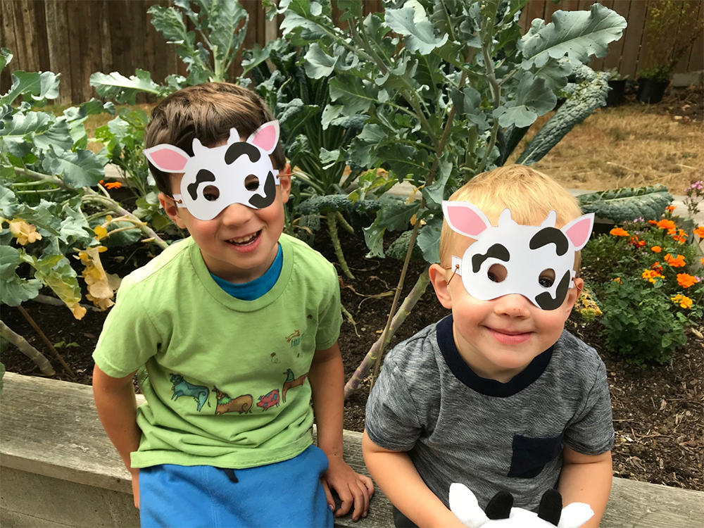 Blake and Archie sport adorable cow masks. Two boys wear cow masks.