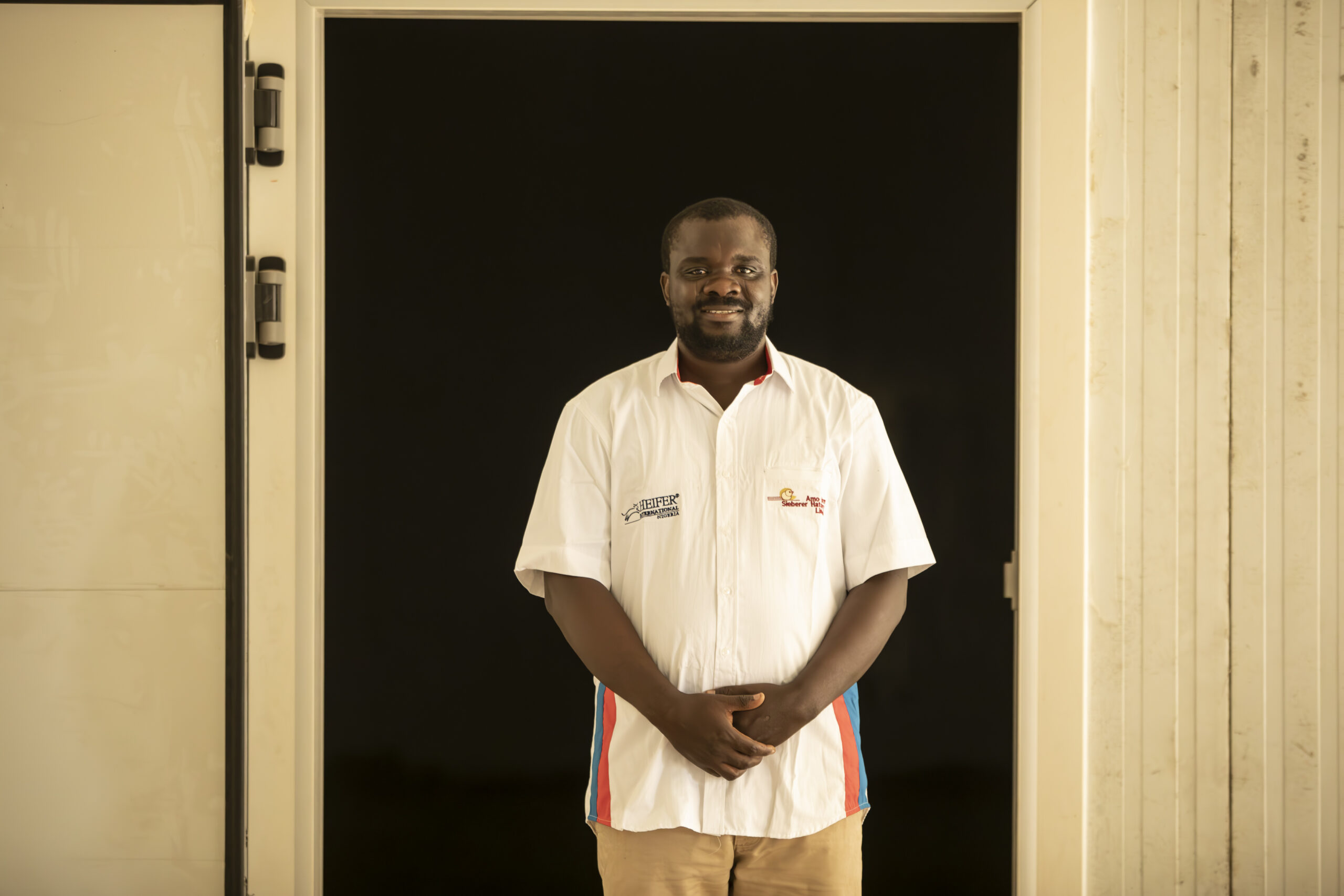 Man standing in an open doorway with his hands crossed over in front of him.