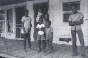 A family involved in the Heifer/Prentiss Institute project in front of their home.