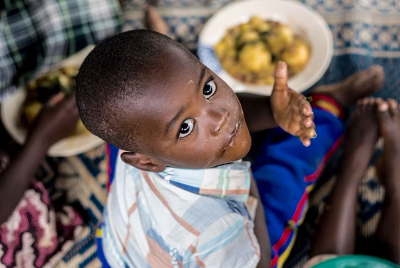 Children enjoy a hearty meal at a community kitchen in Rwanda.