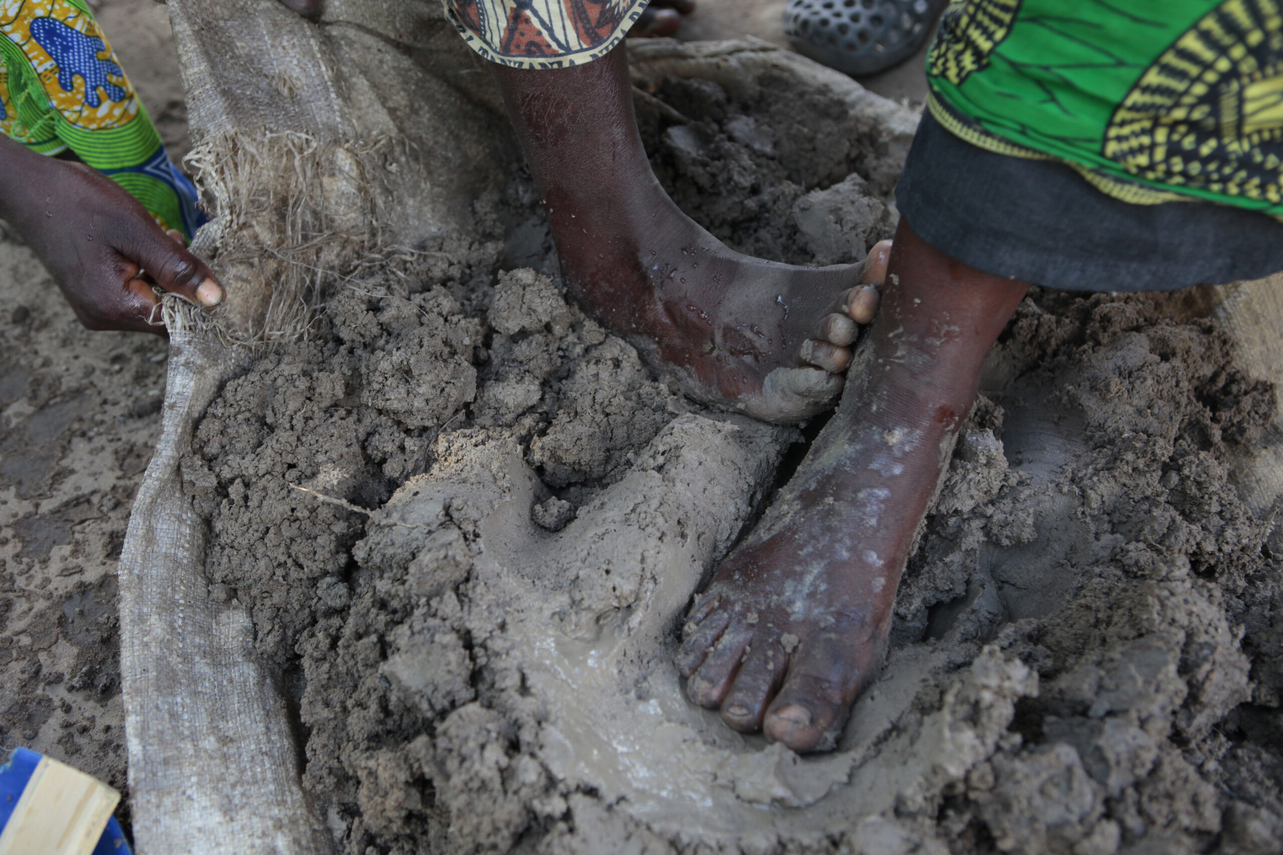 Women of the Gideon village in Malawi mold clay into portable clay stoves. Women of the Gideon village in Malawi mold clay into portable clay stoves with their hands and feet.