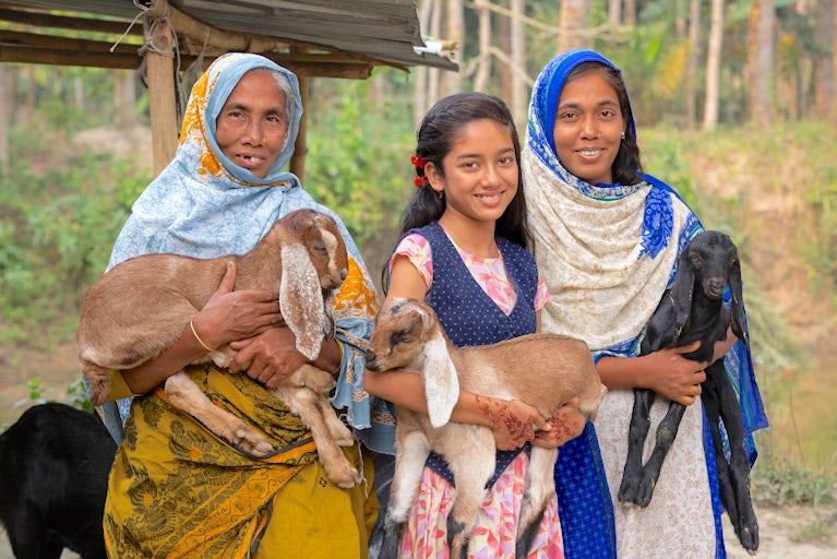 Women holding goats.